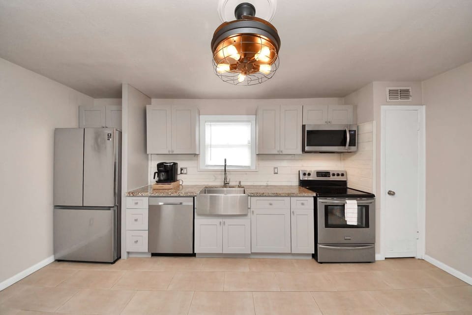 Bright kitchen w/ sleek cabinetry, stainless appliances &amp; open space for easy meal prep