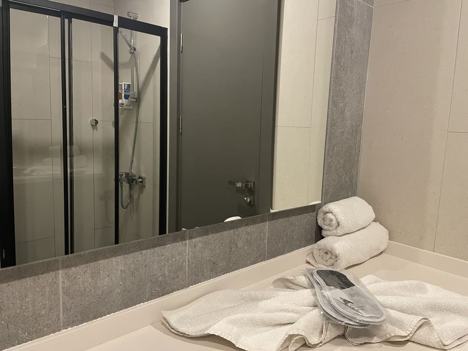 Shower, hair dryer, slippers, towels
