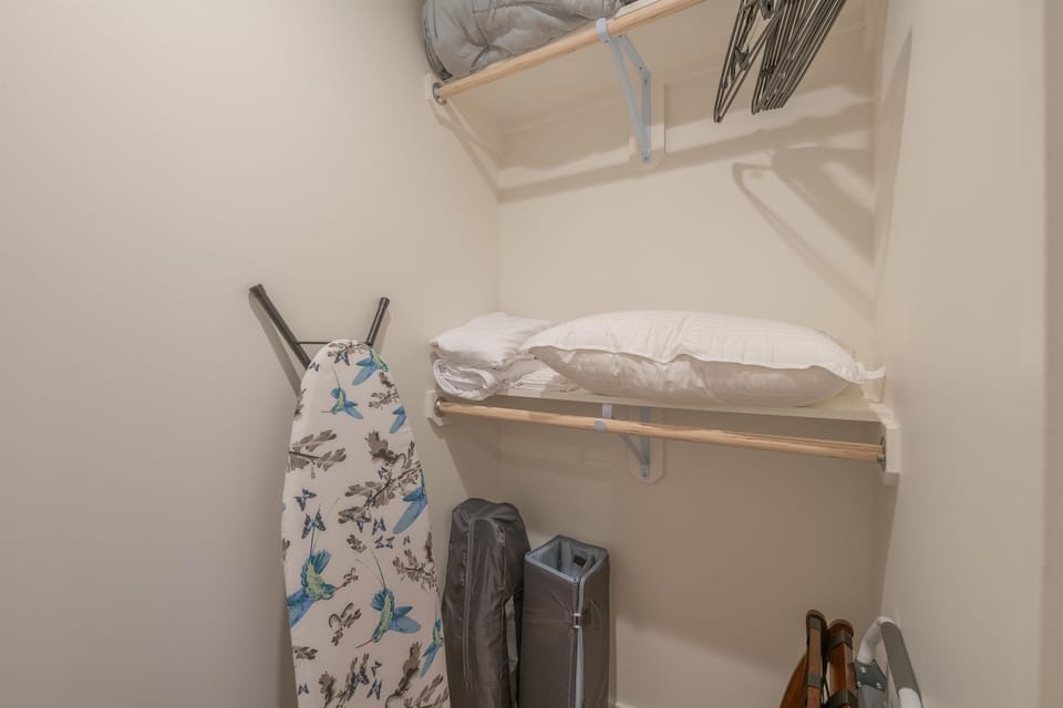 Closet with iron/board, extra linens, luggage stand