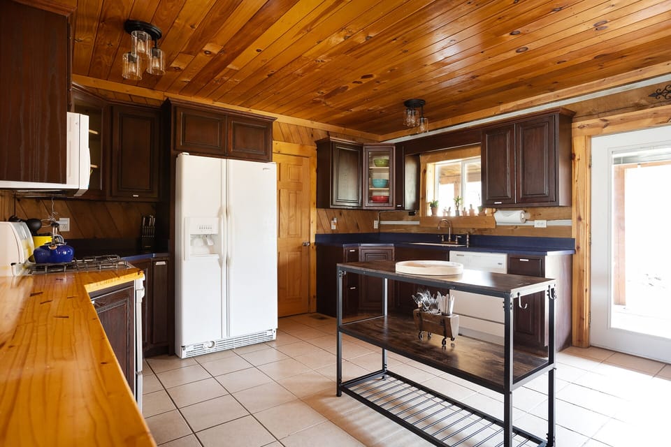 Kitchen area with a center island. Laundry room door next to refrigerator.