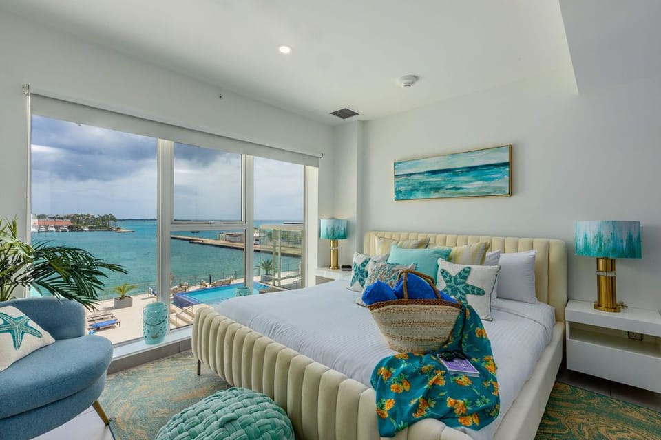 Wake up to stunning turquoise waters and coastal breezes in your serene bedroom retreat. The plush king bed, chic coastal décor, and private waterfront views create your perfect seaside escape.