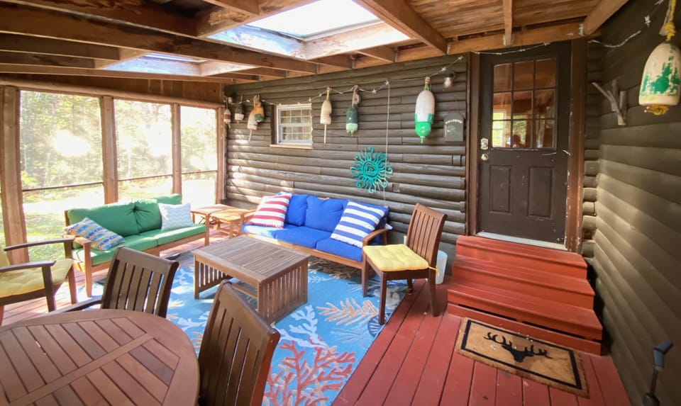 Screened porch with dining area, skylights, LED lights, and door to living room.