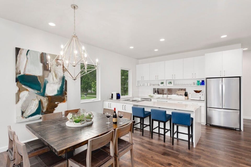 Between the lounge area and the kitchen, you'll see our 8-top dining table as well as 3 barstools lined up against our stunning granite island.