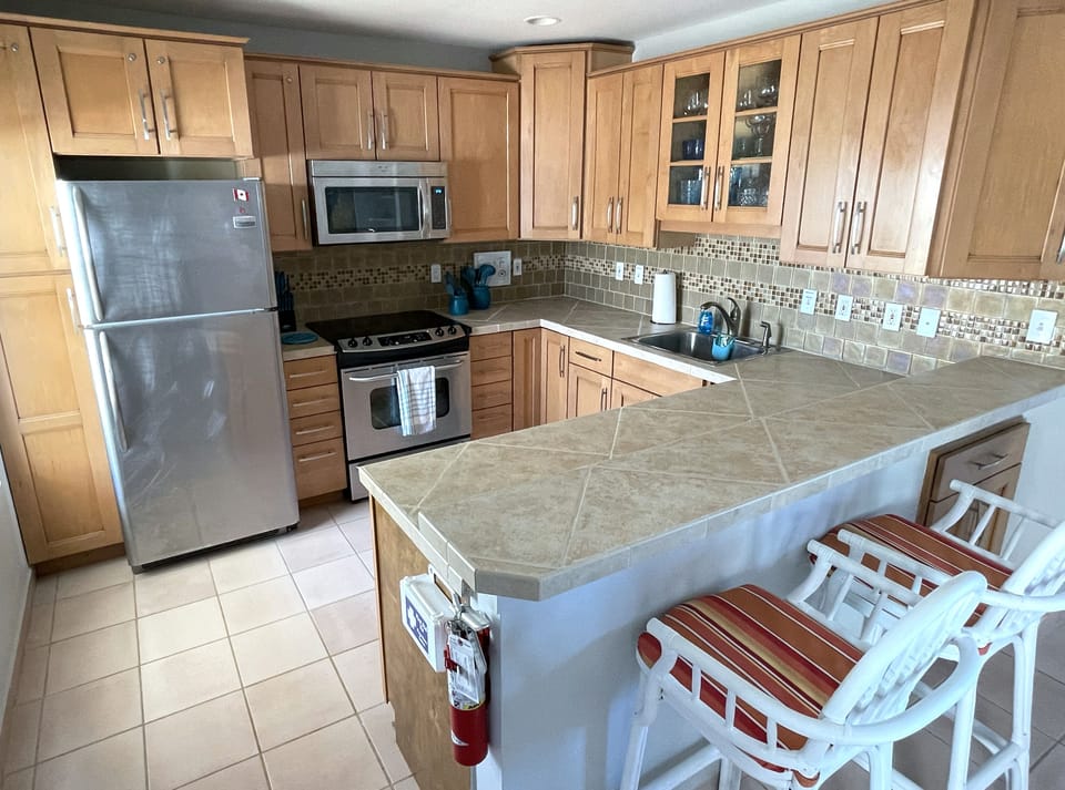 Full-size kitchen with stainless steel appliances and breakfast bar.