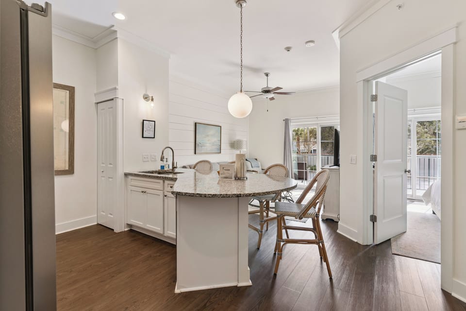Step into this bright, open kitchen where stylish coastal charm meets everyday comfort. Imagine preparing meals at the sleek island, sunlight streaming through windows, with easy access to your private balcony just steps away.