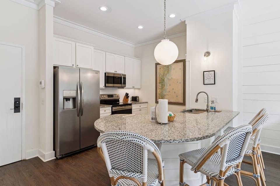 Your bright, open kitchen invites you to gather around the spacious island, where granite counters and stainless appliances make meal prep a breeze in this welcoming coastal retreat.