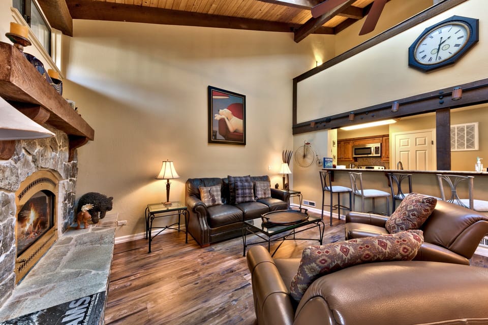 Unwind in your cozy living room with crackling fireplace, leather seating, and rustic charm creating the perfect mountain retreat atmosphere.