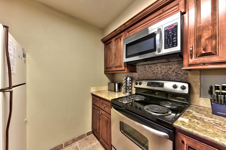 Your fully equipped kitchen features elegant wood cabinetry, granite countertops, and modern appliances for all your culinary adventures.