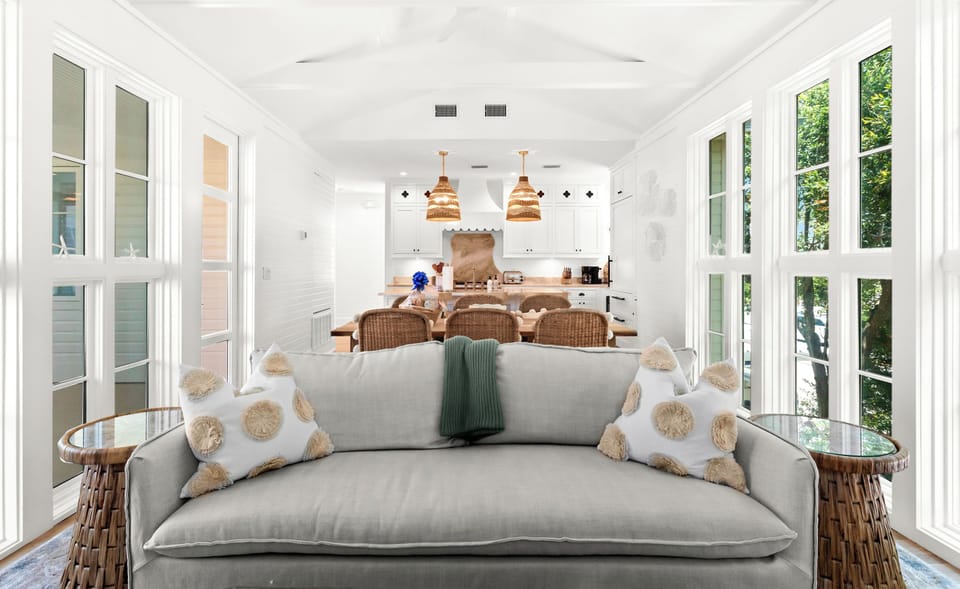 Bright, airy living space flows seamlessly into the kitchen, where natural light pours through floor-to-ceiling windows.