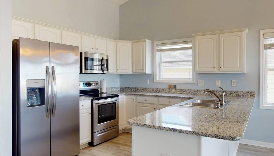 Nice sized kitchen stocked with cookware, dinnerware, baking dishes and utensils