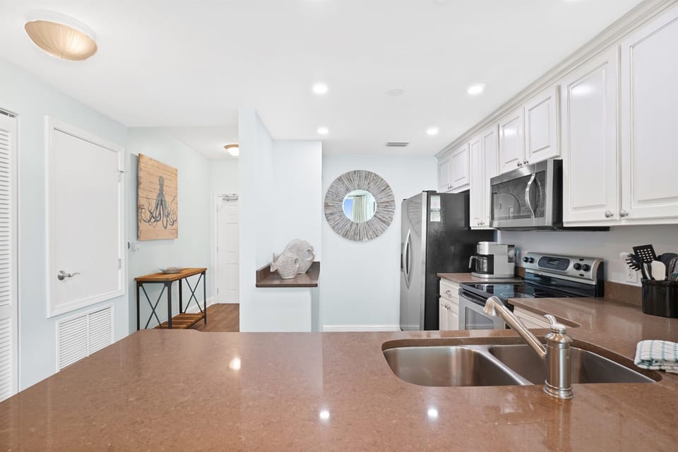 Prepare your favorite meals in this bright, fully-equipped kitchen featuring gleaming counters, stainless appliances, and everything you need for home cooking.