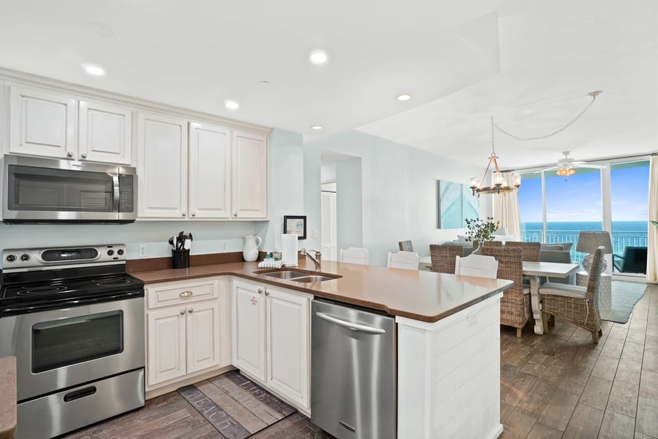 Your fully-equipped kitchen flows seamlessly into the dining space, where ocean views create the perfect backdrop for every meal.