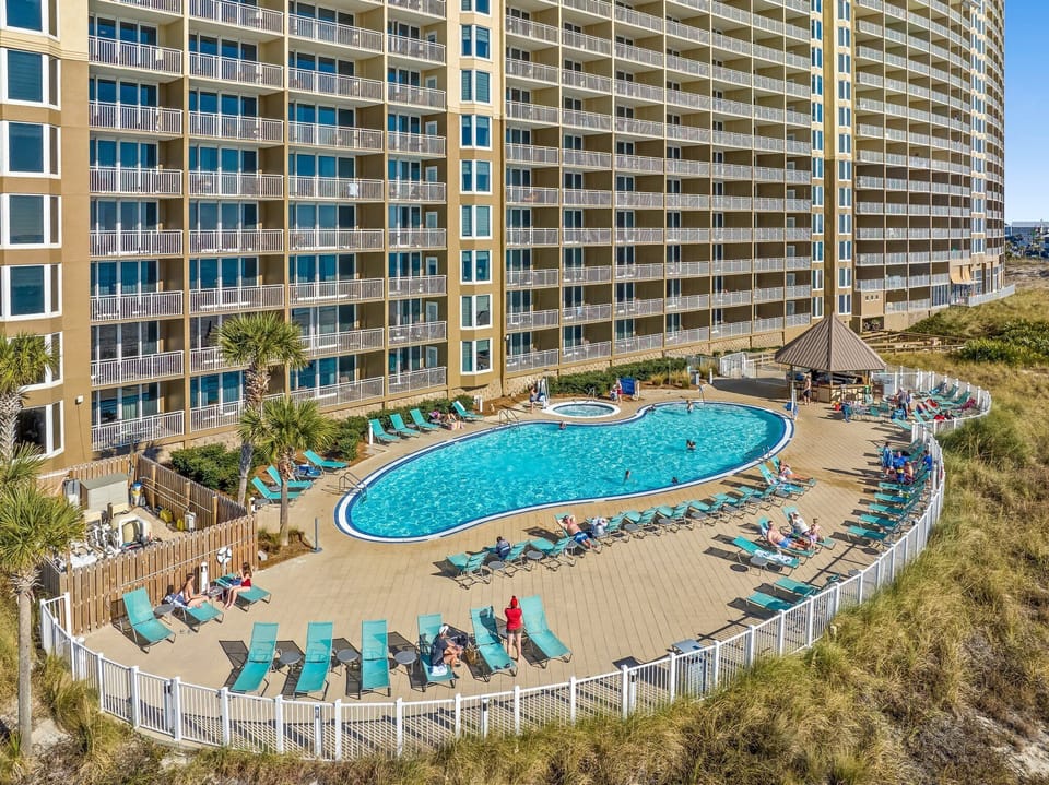 Poolside Paradise: Dive into fun at our stunning pool, surrounded by lush palms, sun loungers, and pool bar!