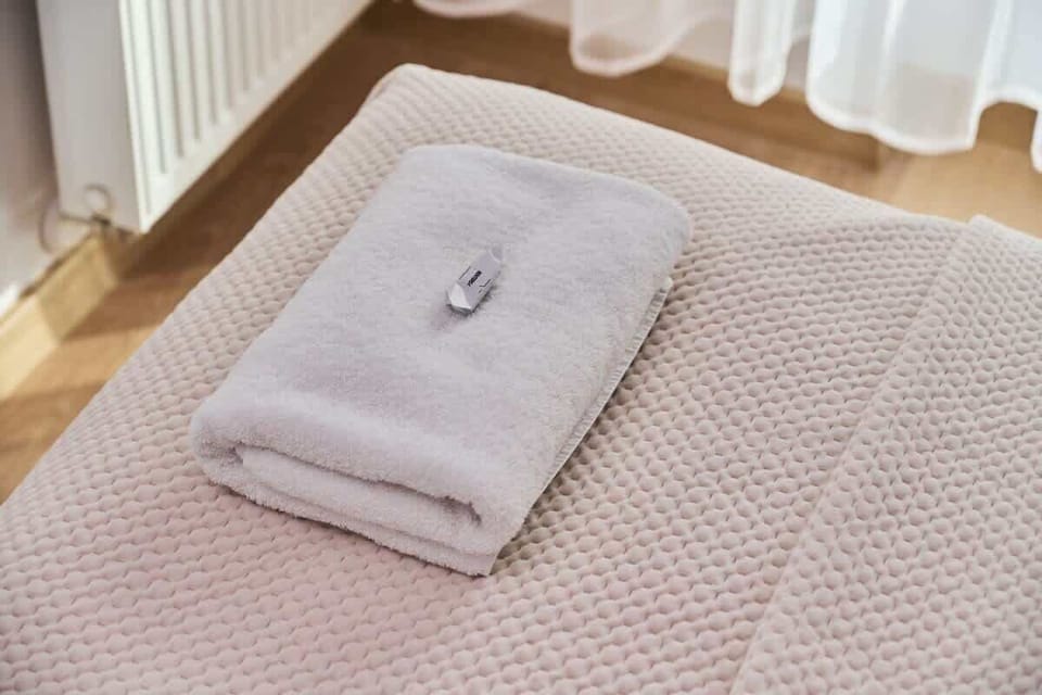 A close-up of neatly folded towels on a bed. The setup feels luxurious and inviting.