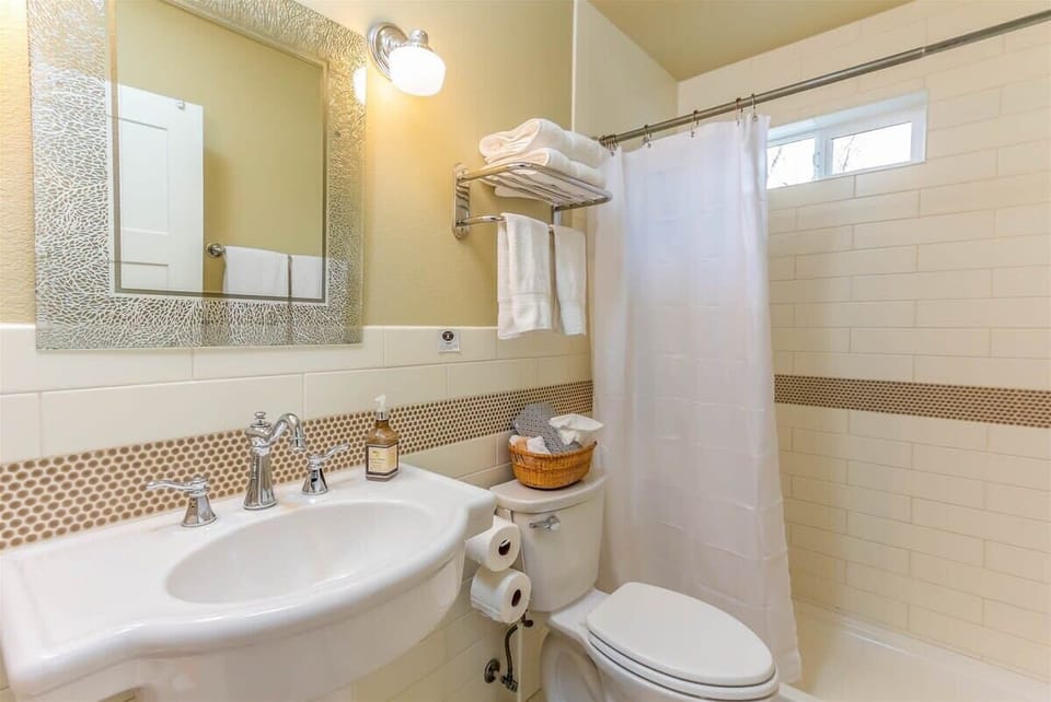 The bathroom has lots of natural light and a spacious shower.