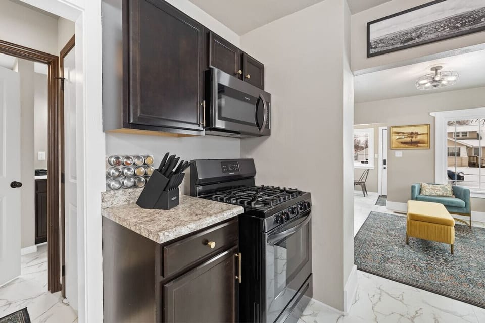 Fully equipped kitchen featuring a stove, microwave, and all the utensils you need for convenient cooking and dining.