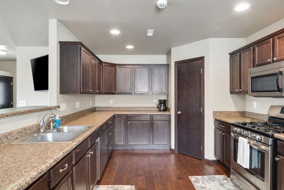 A fully equipped kitchen with cups, bowls, plates, mugs, and silverware is all provided, pots, pans, and cooking utensils.