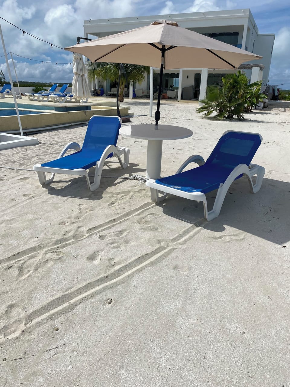 Pool area has sand like beach.