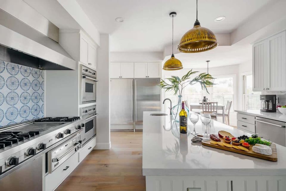Bright fully equipped kitchen with stainless steel appliances, dual ovens, dual sinks, XL fridge, large island and breakfast table with incredible views of Camelback.