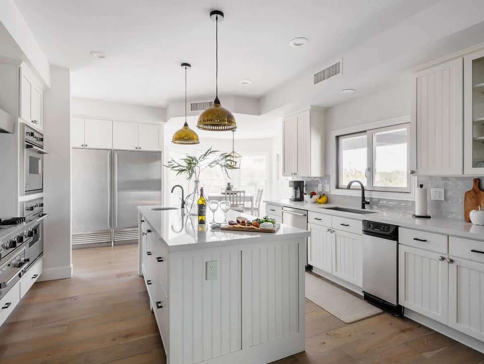 Bright fully equipped kitchen with stainless steel appliances, dual ovens, dual sinks, XL fridge, large island and breakfast table with incredible views of Camelback.