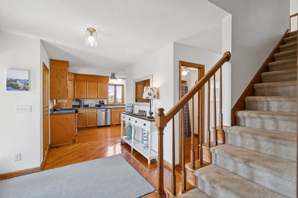 The staircase in the entryway leads to the primary bedroom, two guest bedrooms and a bathroom