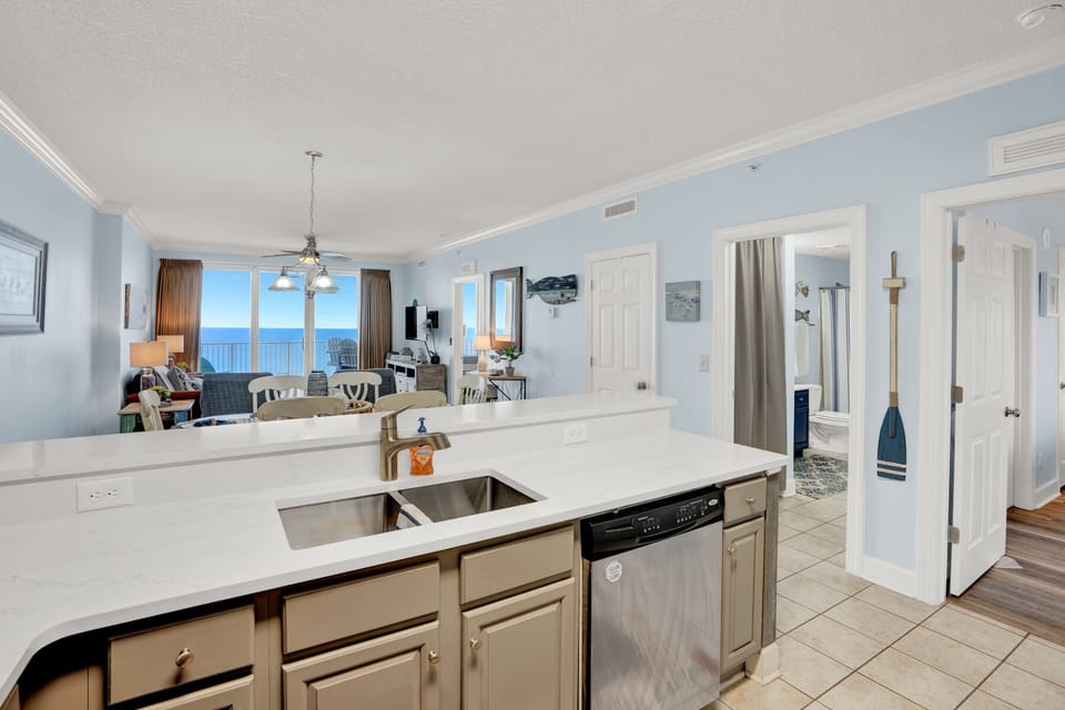 Your open kitchen flows seamlessly into the living space, with stunning ocean views through floor-to-ceiling windows creating the perfect backdrop for cooking and entertaining.