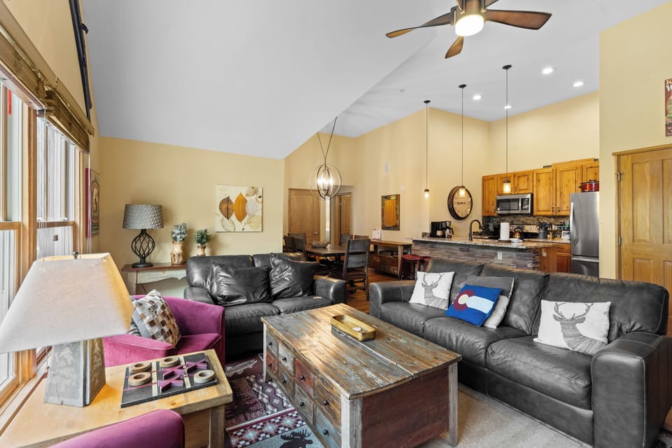 Sink into plush leather sofas in your open-concept living space, where rustic charm meets modern comfort under soaring ceilings.