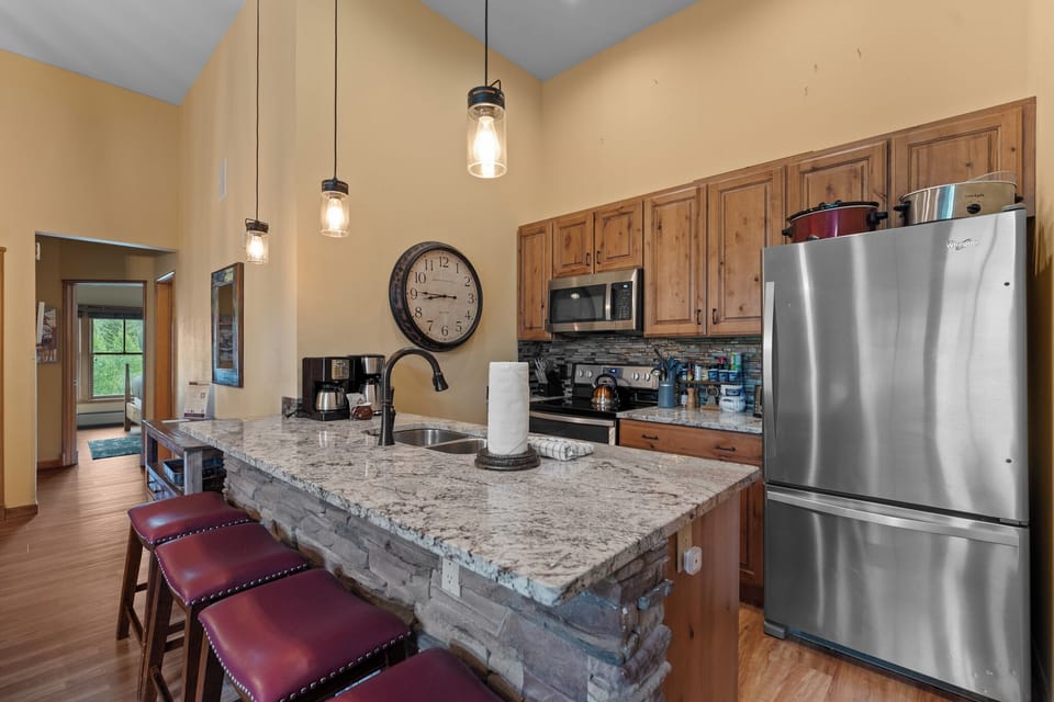 Your spacious kitchen invites culinary adventures with granite counters, stainless appliances, and pendant lighting creating the perfect gathering spot for memorable meals.