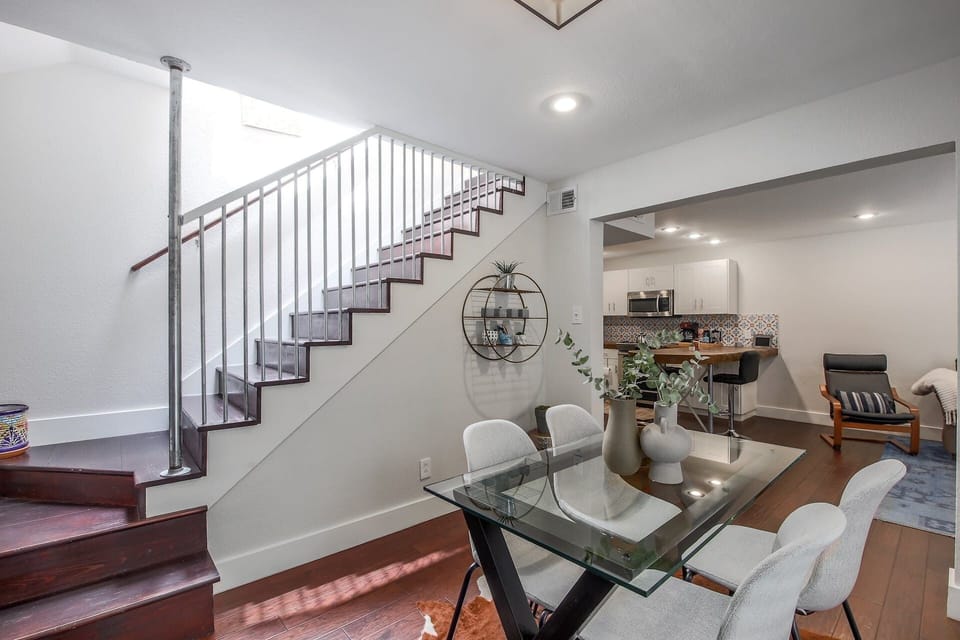 Dining table for four near the stairs leading to the second floor of the house.