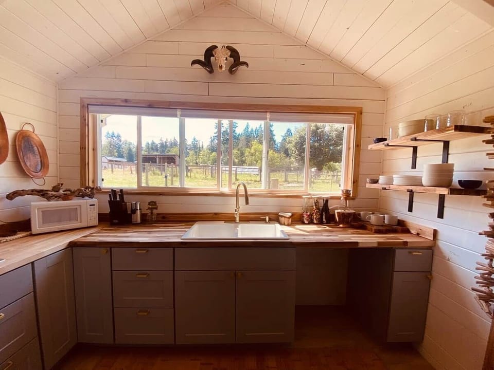 The kitchen overlooks the pasture and has a refrigerator, microwave, stove top, toaster oven, and of course coffee maker.