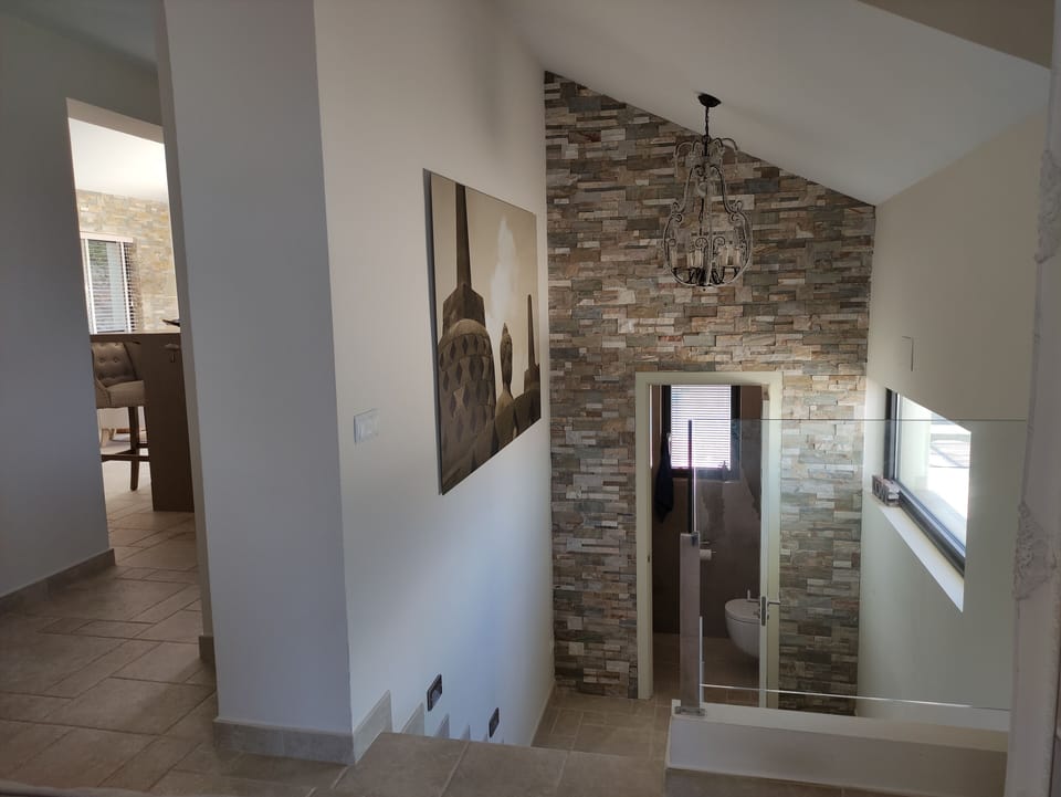 staircase down to the rest of bedrooms level and a guest’s toilet.