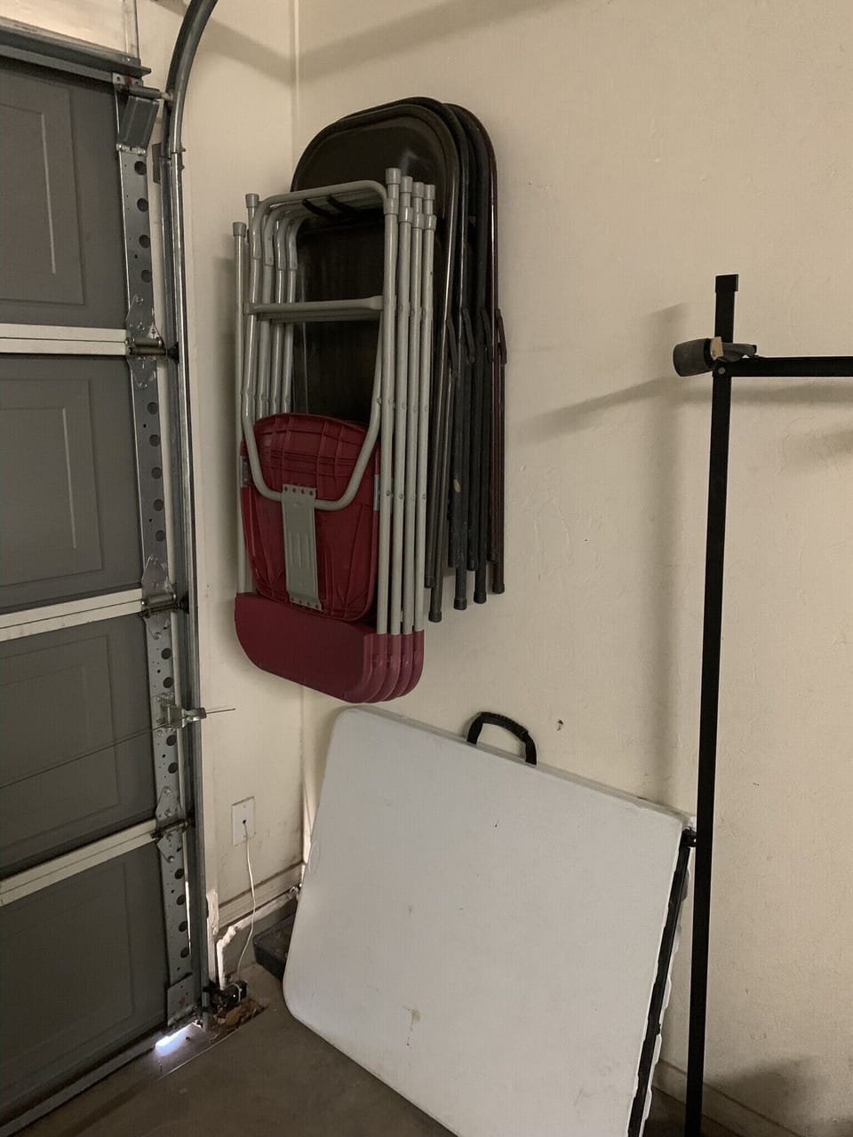 Table and 8 chairs, and single bed frame with mattresses in garage