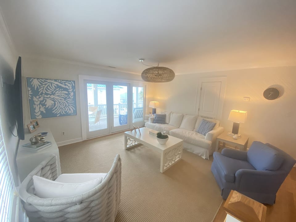 Den opens to kitchen and looks onto ocean 