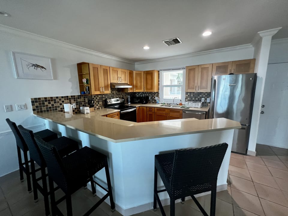 Island with barstool seating and full kitchen. 