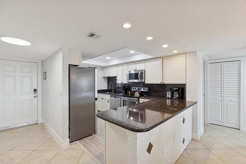Bright and airy kitchen with sleek countertops .