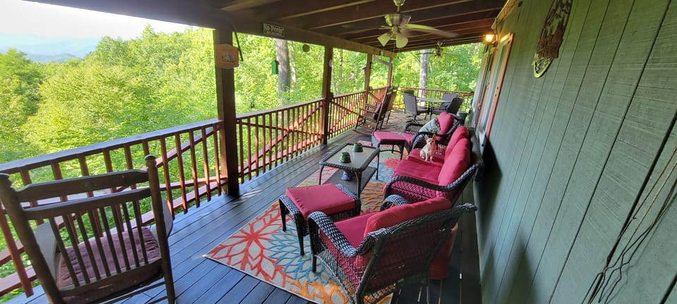Gated dog friendly porch with patio furniture, rocking chairs and dining table 