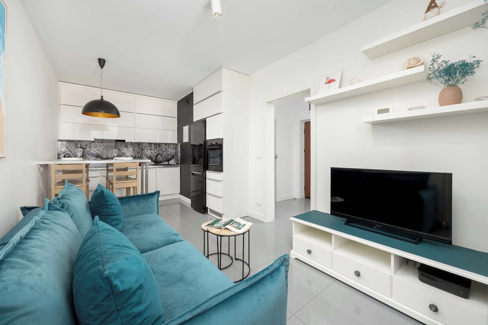 The living room has a comfortable sofa opposite, with a flat-screen TV.
