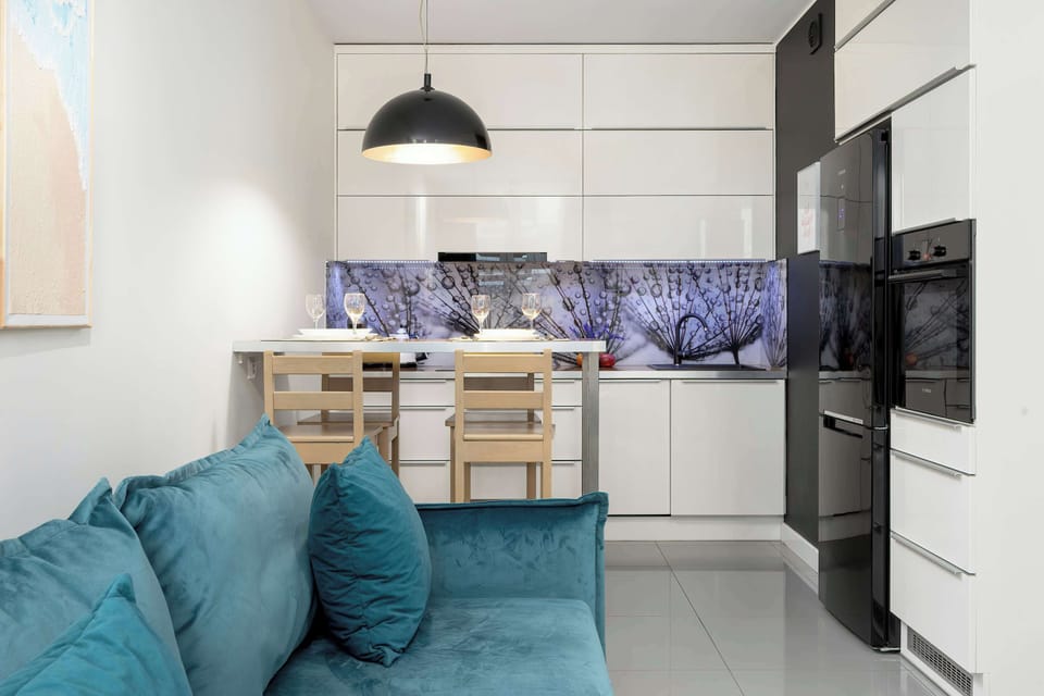 View of the kitchenette with white furniture and black accents.