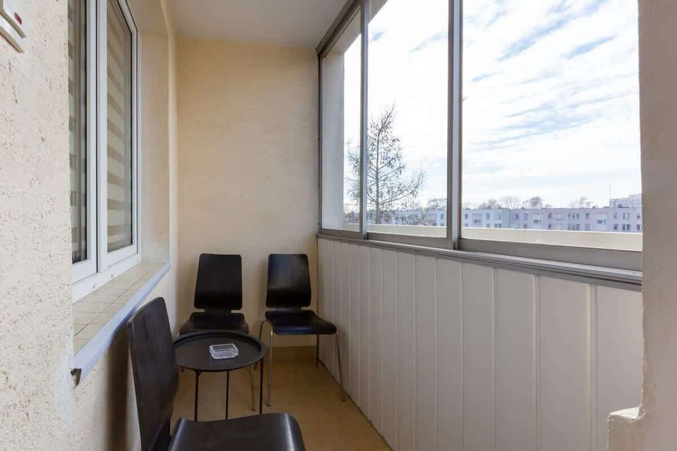 Furnished balcony with green surroundings. 