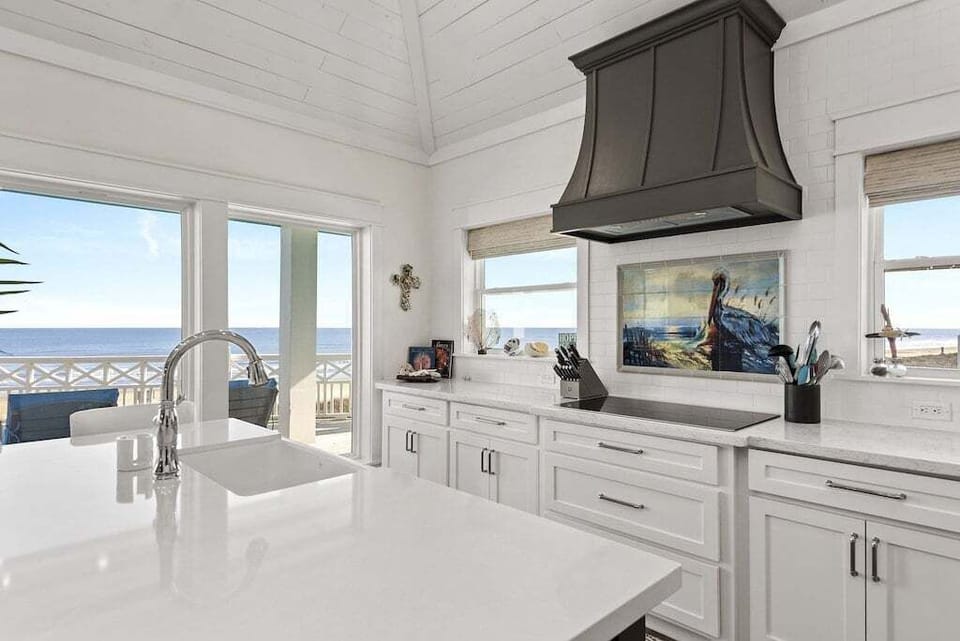 A fully stocked, gourmet kitchen awaits with quartz countertops and Gulf views.