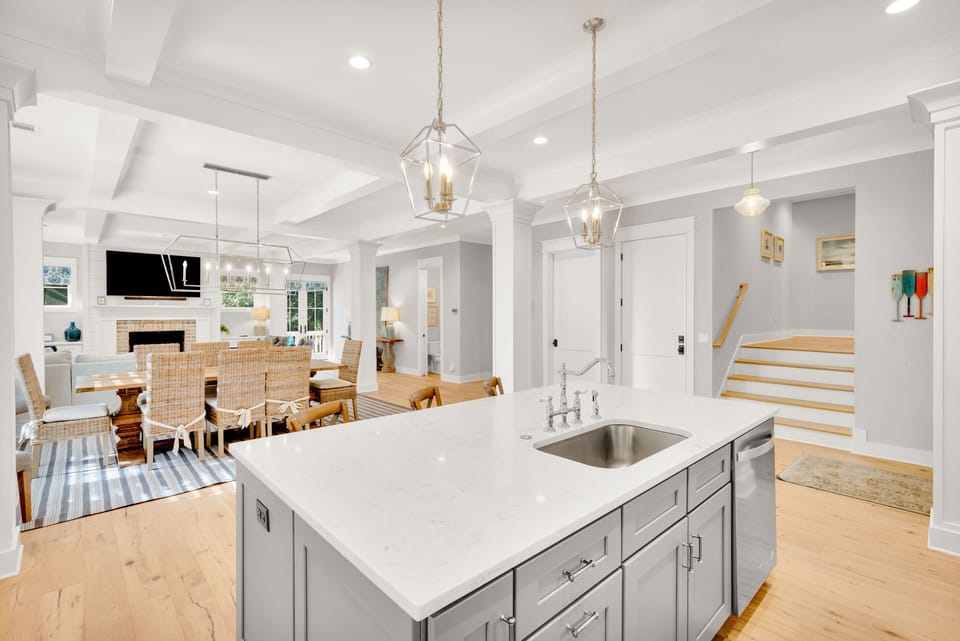 The kitchen offers ample counter space, stainless steel appliances, is fully stocked, and includes three barstools for additional seating.