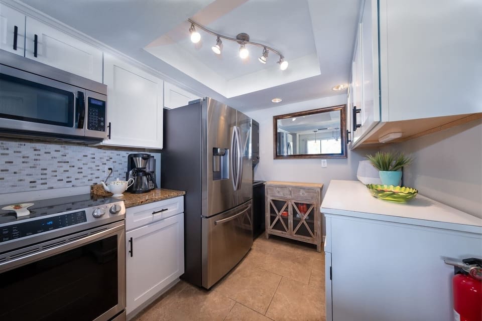 - Stainless appliances and modern backsplash in kitchen   - Bright lighting for smooth cooking time   - Clean organized space ready for meal prep