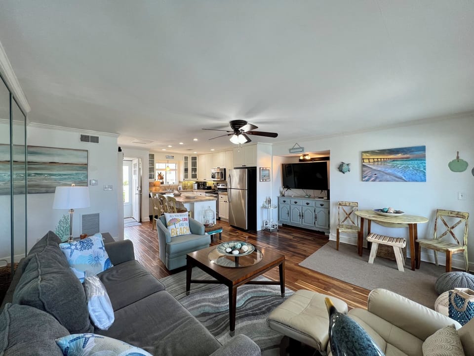 Relax in your coastal-themed living space with plush seating and ocean artwork creating the perfect beach house vibe.
