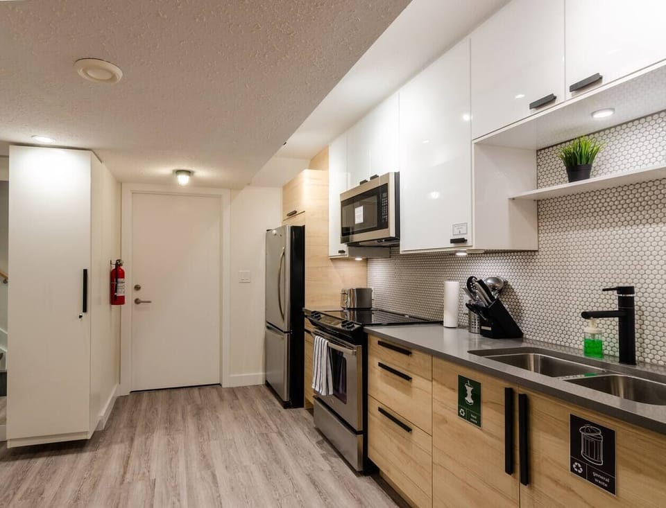 Fully stocked modern kitchen with quartz counters, stainless steel appliances, and all the cookware needed for a gourmet meal