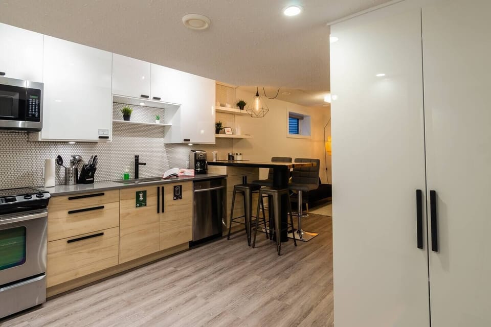 Fully stocked modern kitchen with quartz counters, stainless steel appliances, and all the cookware needed for a gourmet meal