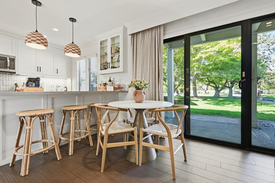 Dine overlooking the greenery, with seating for four plus additional counter seating at the kitchen.