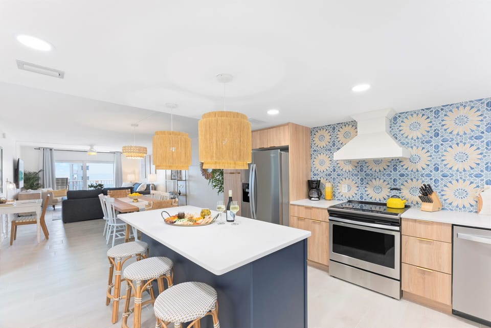 Gourmet kitchen with modern appliances, stylish lighting, and custom tile backsplash.