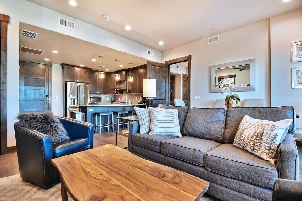 Unwind in our cozy living room featuring a stone fireplace, comfortable seating, and large windows with mountain views. A perfect space to relax after a day outdoors.