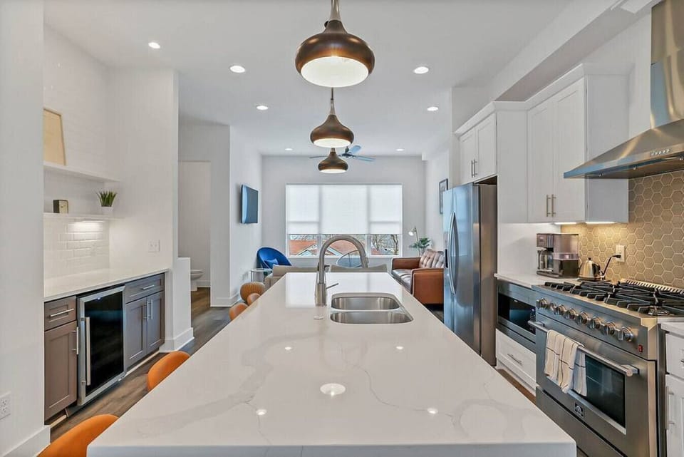 Kitchen island paired with wine bar fridge and stainless steel appliances.