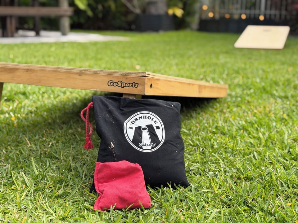 Cornhole bags game boards on upper level of backyard.
